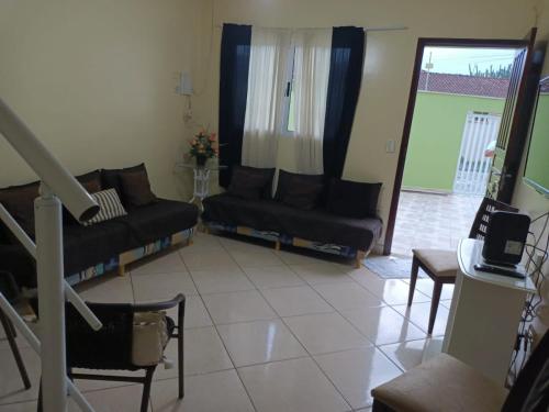 蒙加瓜Lindo Sobrado的客厅设有两张黑色沙发和一个窗户