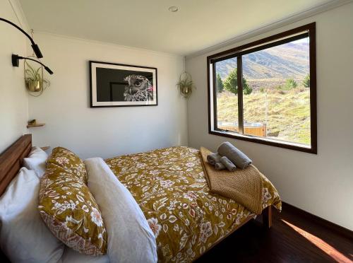 特威泽尔Te Manahuna Retreat的一间卧室设有一张床和一个大窗户