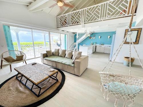 东方湾Princess Anouk Beachfront Orient Bay Deluxe 3 BDR的客厅配有沙发和秋千
