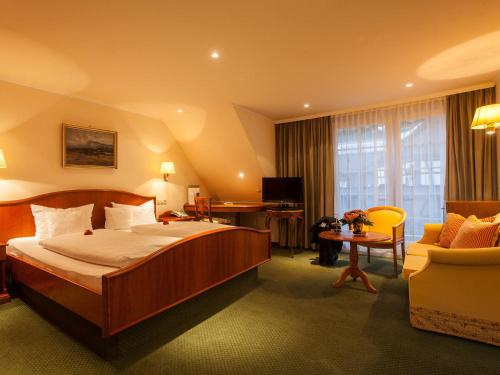 巴登韦勒登日浪漫酒店的酒店客房带一张大床和一把椅子