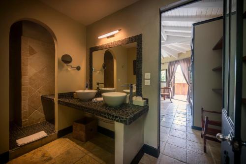 圣马丁岛La Villa Hibiscus, Saint Martin的一间带两个盥洗盆和大镜子的浴室
