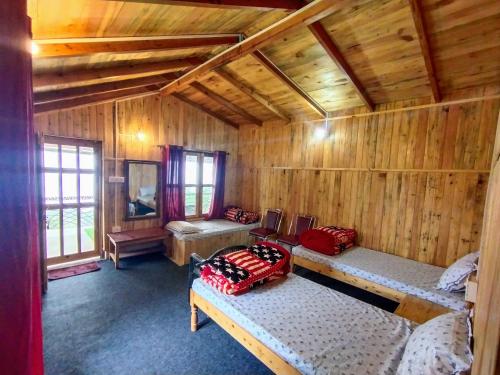 奈尼塔尔Mowgli Town Homestay/Resort的小木屋内带两张床的房间