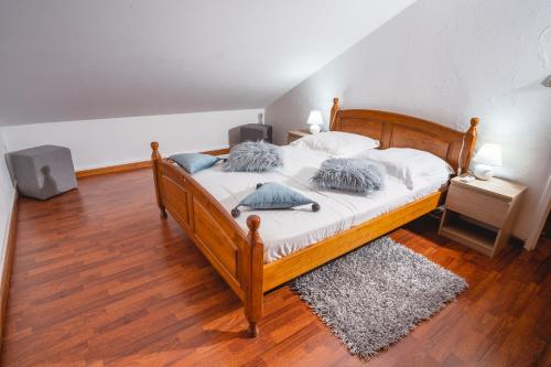 珀蒂蒂勒Le Coin d'Azur的一间卧室配有带白色床单和蓝色枕头的木制床