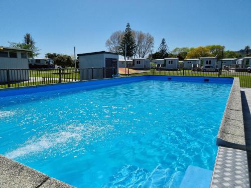 卡塔尼Whakatane Holiday Park的庭院里的一个蓝色海水游泳池