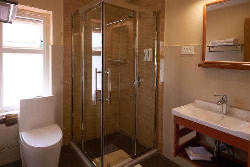 廷布The Willows Hotel, Bhutan的带淋浴、卫生间和盥洗盆的浴室