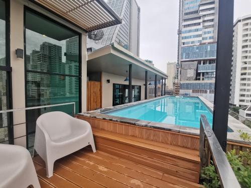 曼谷蓝之调酒店的阳台设有游泳池和白色椅子