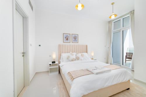 迪拜Immaculate 1BR apartment at Carson C的白色的卧室设有一张大床和一个窗户
