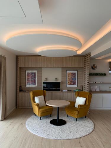 塞克萨德SXRD Luxus Apartmanok的客厅配有桌子和两把椅子