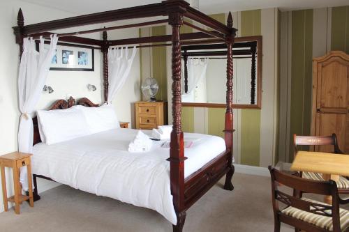 韦茅斯雷德克利夫酒店的一间卧室配有一张天蓬床和一张桌子