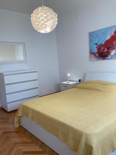 乌马格Casa Letizia的卧室配有一张床,墙上挂有绘画作品