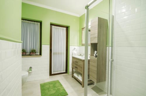 库萨达斯Rodina Suites Hotel的带淋浴、卫生间和盥洗盆的浴室
