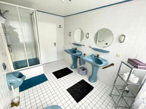 策勒Villa Ferienhaus EMG für Familien und Gruppen in Celle Hannover的浴室设有2个蓝色水槽和淋浴。