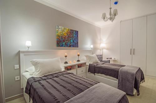 库萨达斯Rodina Suites Hotel的一间卧室设有两张床,墙上挂着一幅画