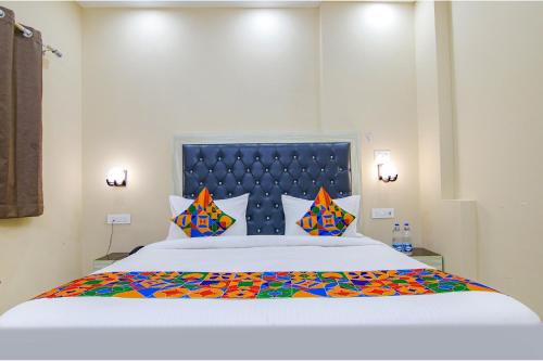 新德里FabHotel Ashok Vihar的一间卧室配有一张带色彩缤纷枕头的大床