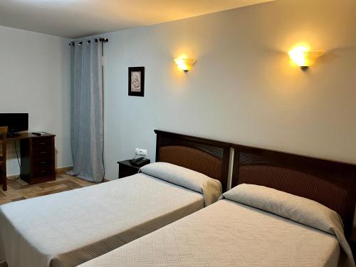 扎弗拉塞万提斯酒店 的一间卧室配有两张床,墙上有两盏灯
