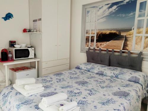 阿祖罗港La Casa di Berenice a Porto Azzurro的一间卧室配有带毛巾的床