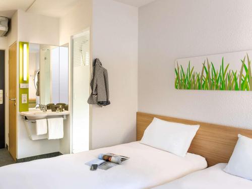 里昂里昂热尔兰宜必思快捷酒店的一间卧室设有两张床、一个水槽和镜子