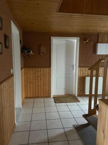 NeuhausGünstig übernachten am Ostseestrand的一间设有白色门和瓷砖地板的客房