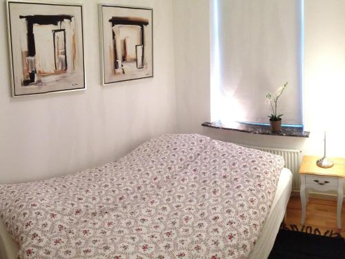 海宁海宁城市公寓的卧室配有一张床,墙上挂有两张照片