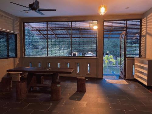 邦咯Pangkor Nature View House的一间带桌子和大窗户的用餐室