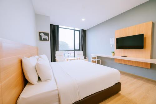 瓜埠Chill Suites Langkawi的酒店客房,配有床和电视