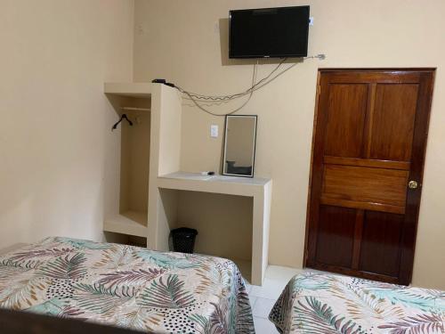 萨利纳克鲁斯Casa de los abuelos的卧室配有一张床,墙上配有电视。