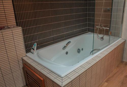 Alins萨罗利亚酒店的带浴缸的瓷砖浴室,配有淋浴