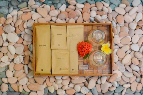 珀尼达岛The MG Villa & SPA的一张桌子,上面有书和花瓶,放在岩石上