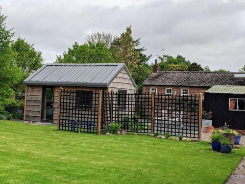 布兰普顿La'al Cabin, tiny home, unique space Eden Valley Cumbria的房屋旁院子的围栏