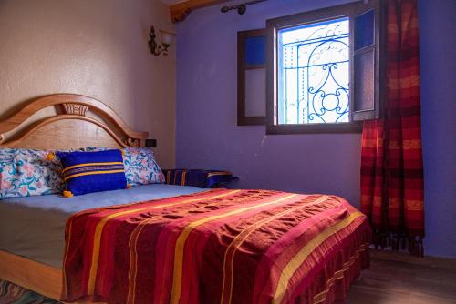 舍夫沙万Blue House Town的一间卧室配有一张带彩色玻璃窗的床