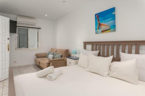 美洲海滩Casa Julia的卧室配有一张白色的大床和一张沙发。