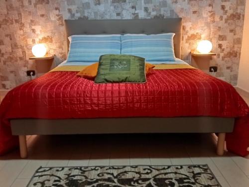 巴列塔Casa-B&B Bouganville Attico 85 mq的一张带红色被子和两盏灯的床