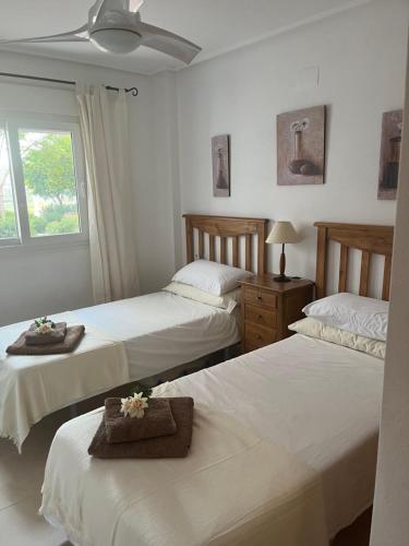 穆尔西亚La Casa Rosita, Hacienda Riquelme Golf Resort Sucina的一间带三张床和吊扇的卧室
