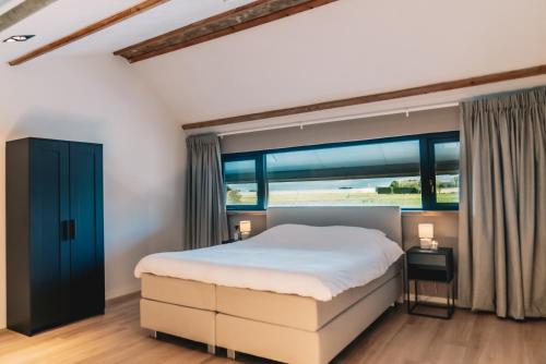 MaaslandWellness Bed & Breakfast by Leef的一间卧室设有一张床和一个大窗户