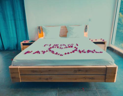 藻德济2 0 HÔTEL Vanille的一张床上有一大束红花