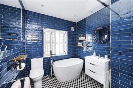Boston SpaSt Mary's Cottage的蓝色瓷砖浴室设有浴缸和卫生间