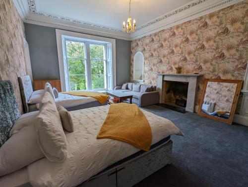 BonnybridgeBonnyside House的一间设有两张床和壁炉的大卧室