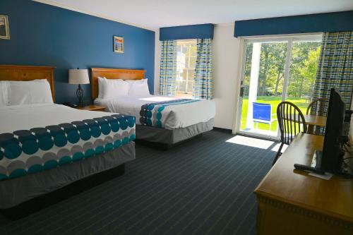杰克逊The Lodge at Jackson Village的酒店客房设有两张床和窗户。