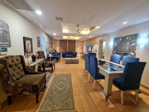伊斯兰堡Royal Residencia Centaurus的客厅配有蓝色的椅子和桌子
