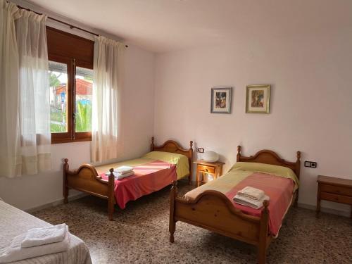 萨洛Casa la Pineda Salou, playa y Port Aventura的一间卧室设有两张床和窗户。