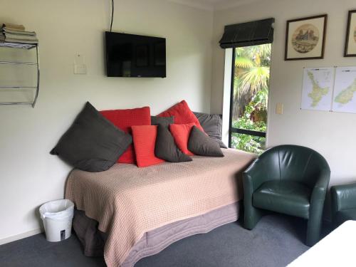 奥雷瓦银谷花园住宿加早餐旅馆的一间卧室配有一张带红色枕头的床和一把椅子