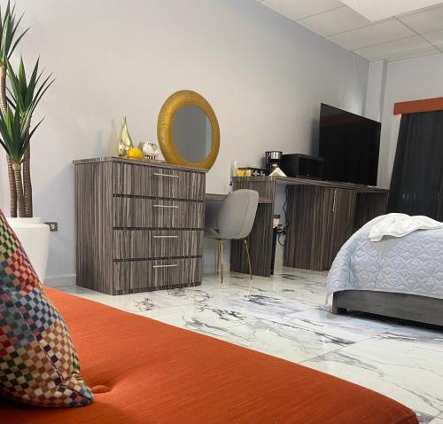 伊莎贝拉Itza-Bella Suites的一间卧室配有一张床、一张书桌和一面镜子