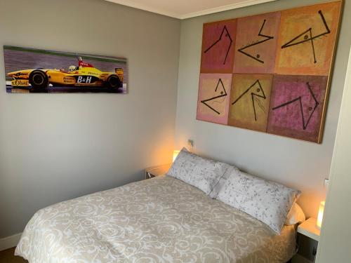 桑坦德Apartamento Puerto Deportivo Marina de Santander的卧室配有一张床,墙上挂有赛车