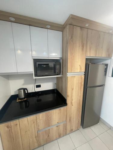 利马Departamento completo Surquillo/Miraflores的厨房配有白色橱柜和不锈钢冰箱