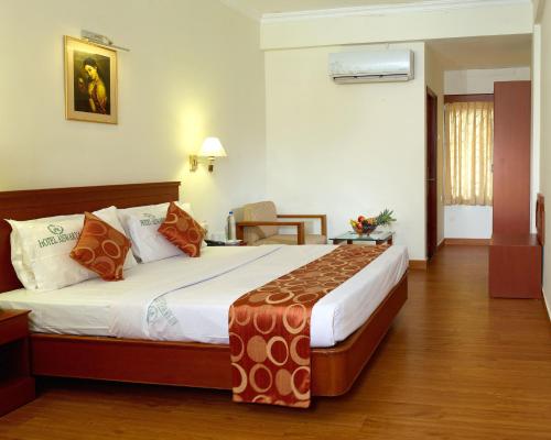 科钦艾斯瓦亚酒店的一间卧室,卧室内配有一张大床