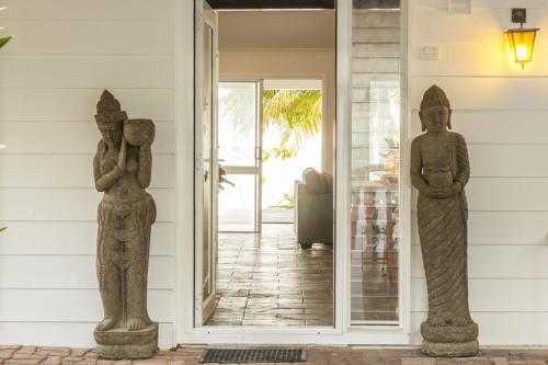 Holloways Beach漂流海滩逍遥度假屋的房屋前廊上的两座雕像