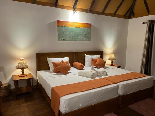 蒂瑟默哈拉默Saffron Lake Yala的一间卧室配有一张大床和两盏灯