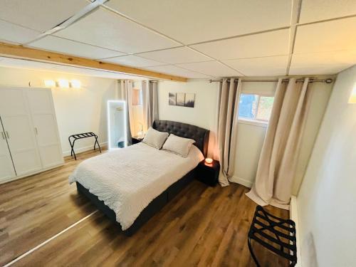 北哈特利Sweet Home des Suites North Hatley的一间卧室配有一张床,铺有木地板