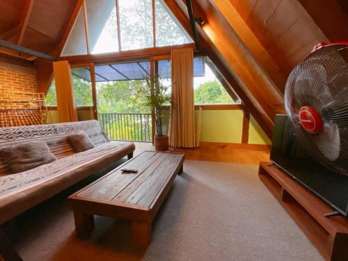 龙目岛库塔Comfortable Wood House second floor and attic的带沙发和风扇的客厅