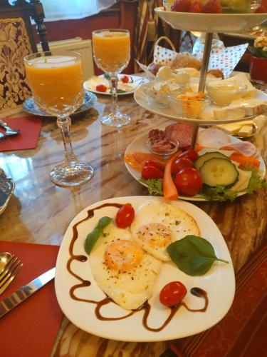 布兰肯堡Villa Imperia, Museums-Hotel的餐桌,带食物盘和橙汁杯